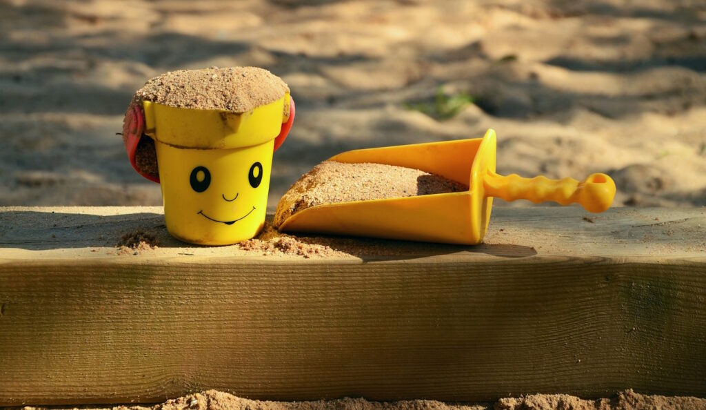 Das Foto zeigt Sand in einem Eimer und in einer Schaufel