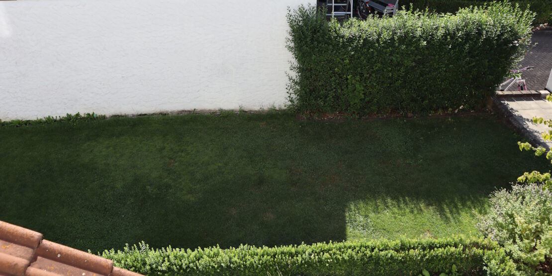 Das Foto zeigt einen Schattenplatz neben einer Mauer