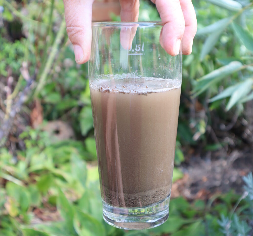 Das Foto zeigt ein Glas, in dem sich Erde befindet. Die verschiedenen Schichten sind zu sehen.