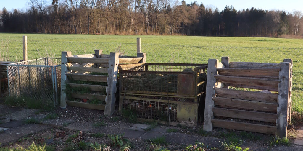 Das Foto zeigt drei Komposter in einem großen Garten nebeneinander