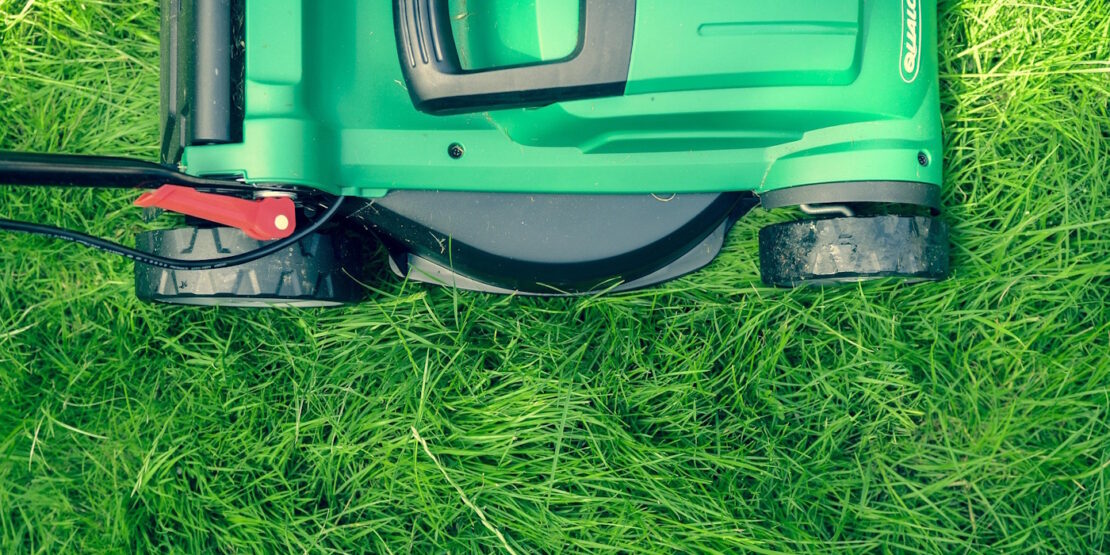 Das Foto zeigt einen Rasenmäher im Gras von einer Vogelperspektive