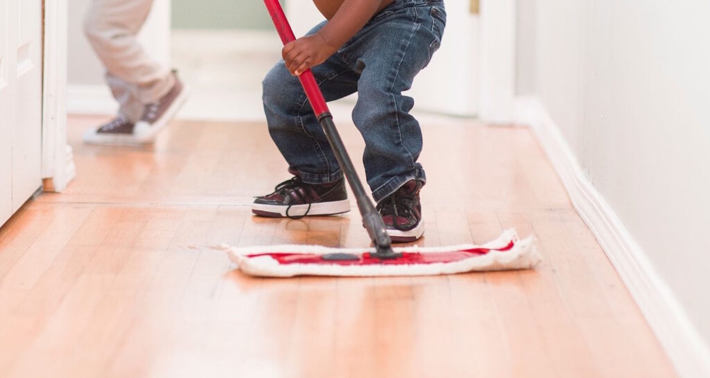 Das Foto zeigt wie ein Boden mit dem Wischmopp gesäubert wird