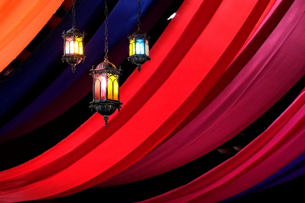 Das Foto zeigt Laternen und rote Stoffbahnen