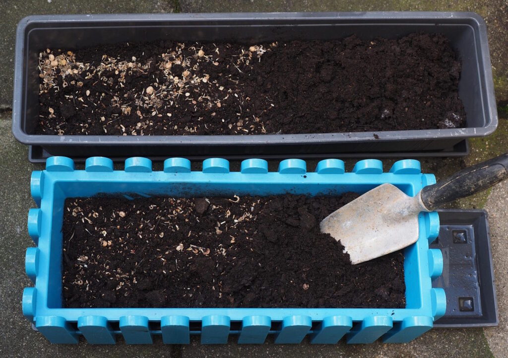 Das Foto zeigt zwei Pflanzgefäße mit Erde