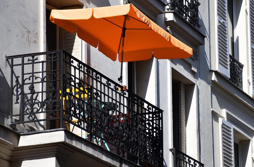 Das Foto zeigt einen Sonnenschirm auf einem Balkon