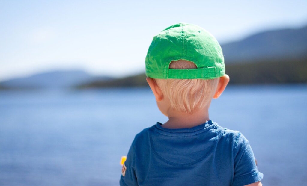 Das Foto zeigt ein Kind mit Sonnencap