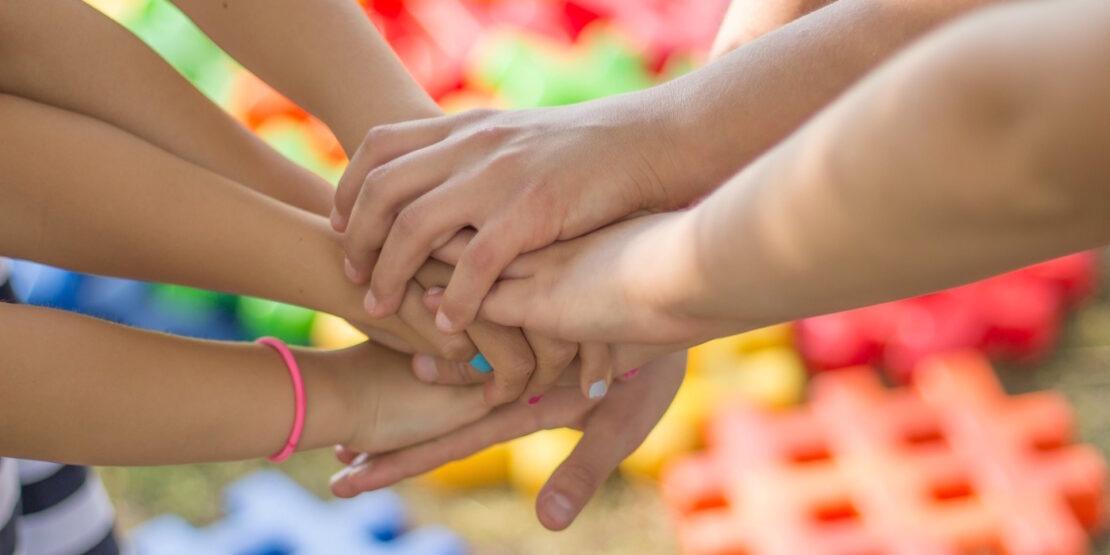 Das Foto zeigt mehrere Kinderhände aufeinander